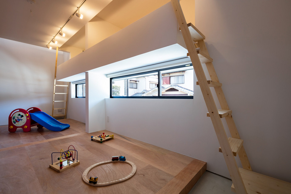 This is an example of a mid-sized scandinavian gender-neutral kids' playroom for kids 4-10 years old in Osaka with white walls, plywood floors and brown floor.