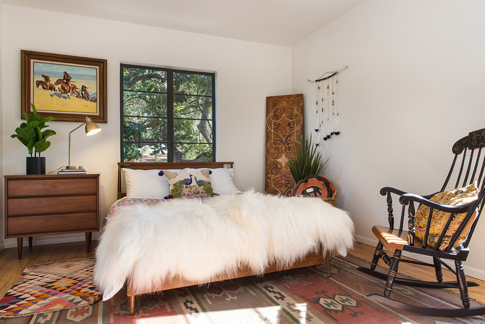 Eclectic guest medium tone wood floor and beige floor bedroom photo in Los Angeles with white walls
