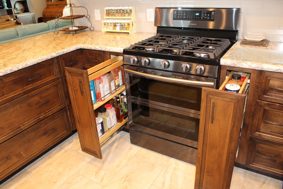 Transitional u-shaped porcelain tile eat-in kitchen photo with flat-panel cabinets, medium tone wood cabinets, laminate countertops, beige backsplash and stainless steel appliances