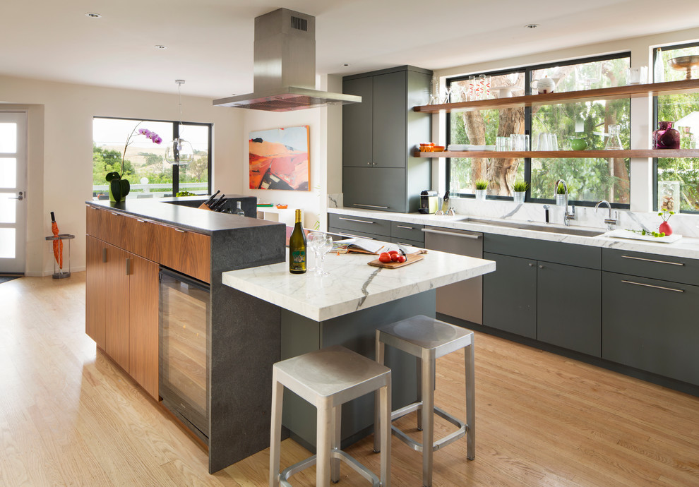 Inspiration for a mid-sized contemporary galley eat-in kitchen in San Francisco with an undermount sink, flat-panel cabinets, grey cabinets, marble benchtops, white splashback, stone slab splashback, stainless steel appliances, light hardwood floors and with island.