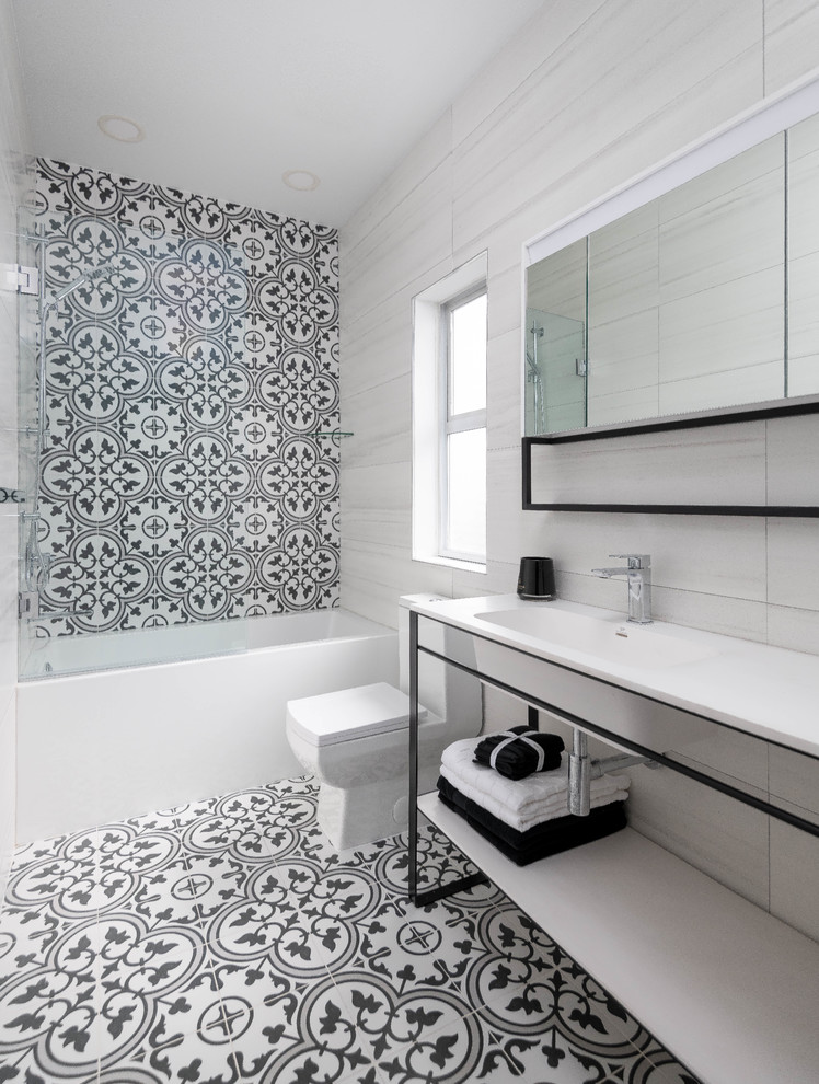 This is an example of a mid-sized contemporary master bathroom in Vancouver with black cabinets, an alcove tub, a shower/bathtub combo, a one-piece toilet, white tile, porcelain tile, black walls, porcelain floors, an integrated sink, engineered quartz benchtops, black floor, a hinged shower door, white benchtops, open cabinets, a single vanity and a freestanding vanity.