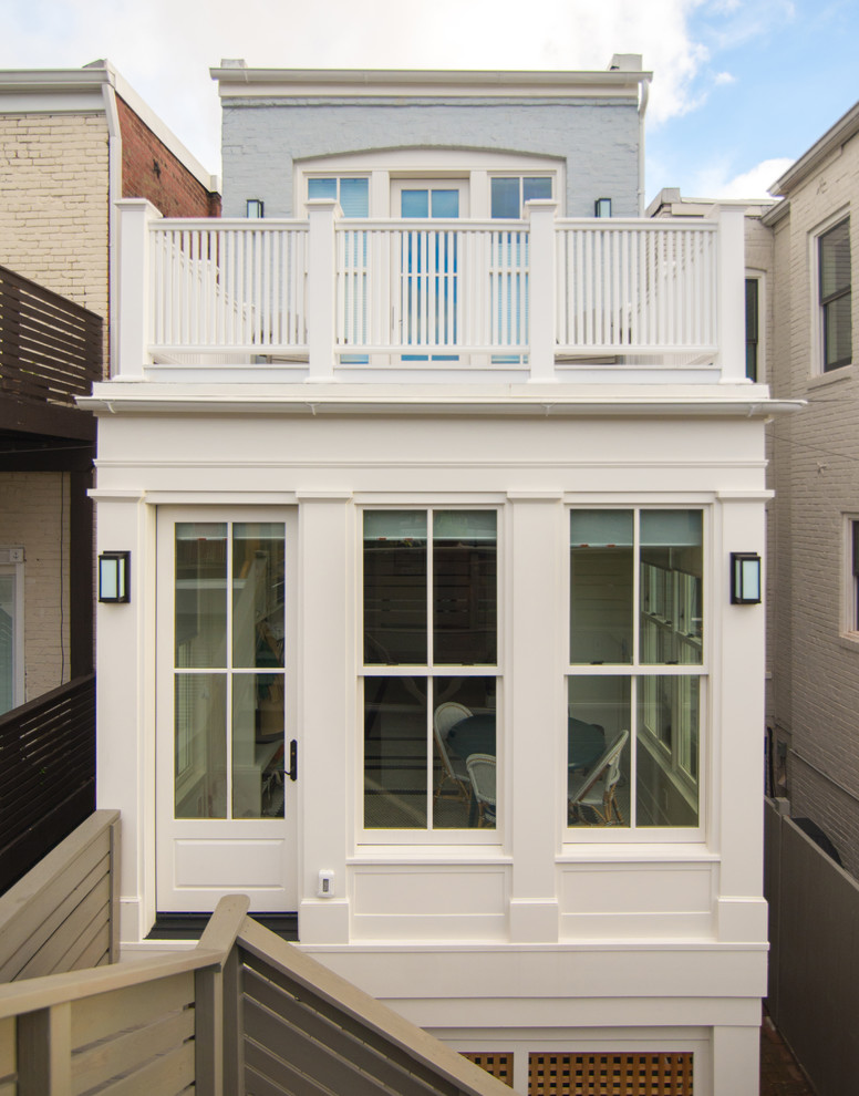 Photo of a mid-sized traditional two-storey white townhouse exterior in DC Metro with mixed siding, a flat roof and a green roof.