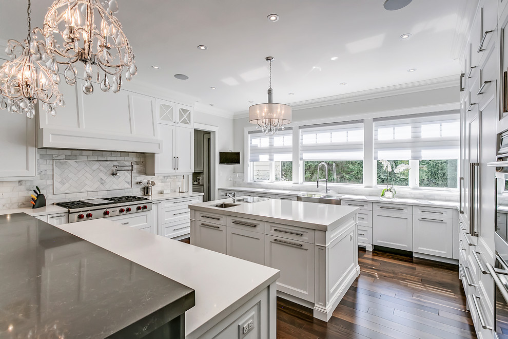 Inspiration for a traditional u-shaped kitchen in Toronto with a farmhouse sink, shaker cabinets, white cabinets, white splashback, panelled appliances, dark hardwood floors and with island.