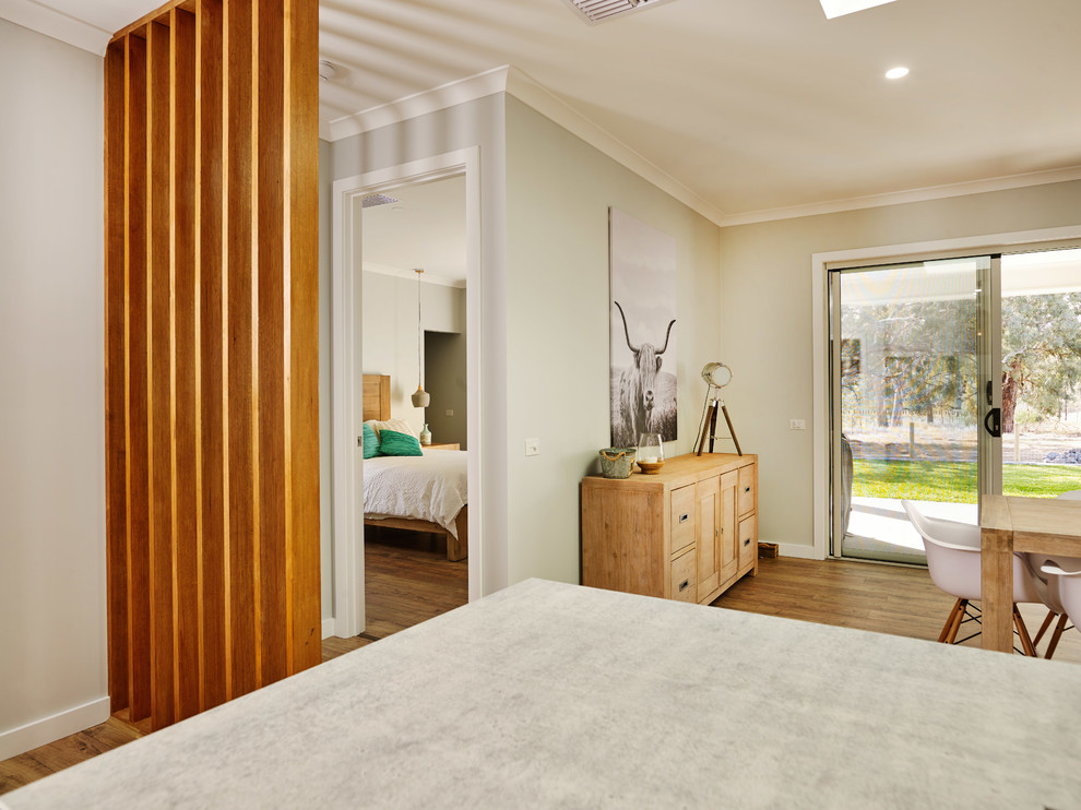This is an example of a mid-sized transitional master bedroom in Other with grey walls, laminate floors and brown floor.