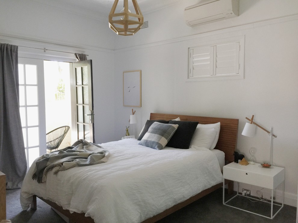 Mid-sized scandinavian master bedroom in Sydney with white walls and carpet.