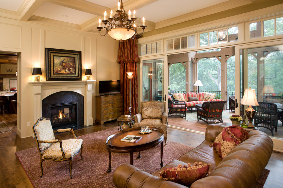 Inspiration for a large traditional open concept living room in Minneapolis with beige walls, medium hardwood floors, a freestanding tv and a two-sided fireplace.