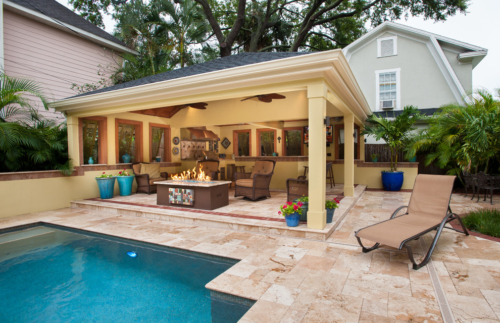 This is an example of a large mediterranean backyard rectangular lap pool in Tampa with a pool house and natural stone pavers.