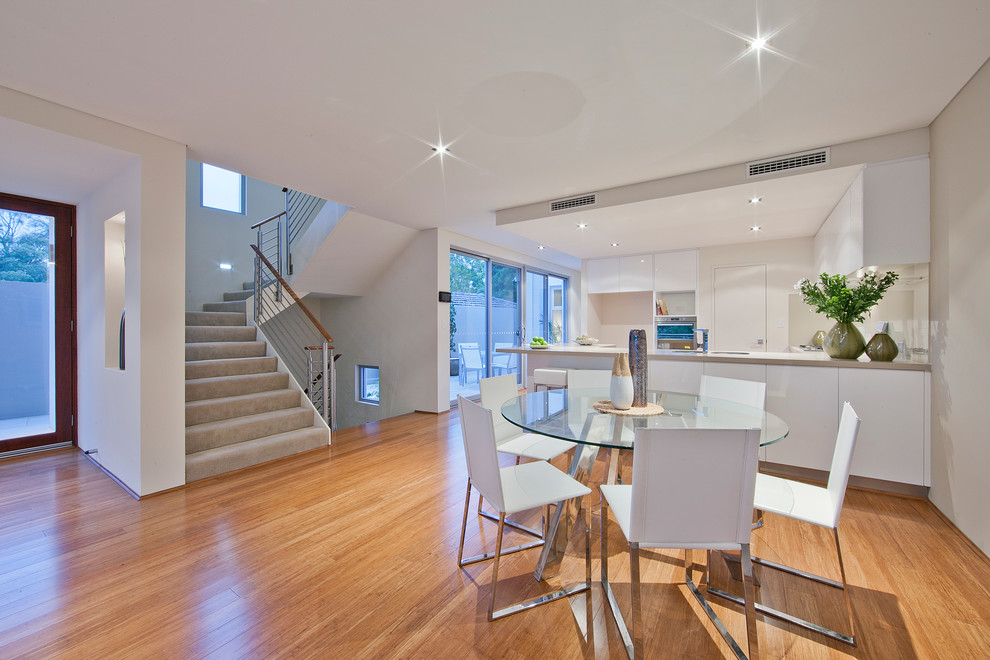 Inspiration for a mid-sized modern kitchen/dining combo in Perth with white walls and light hardwood floors.