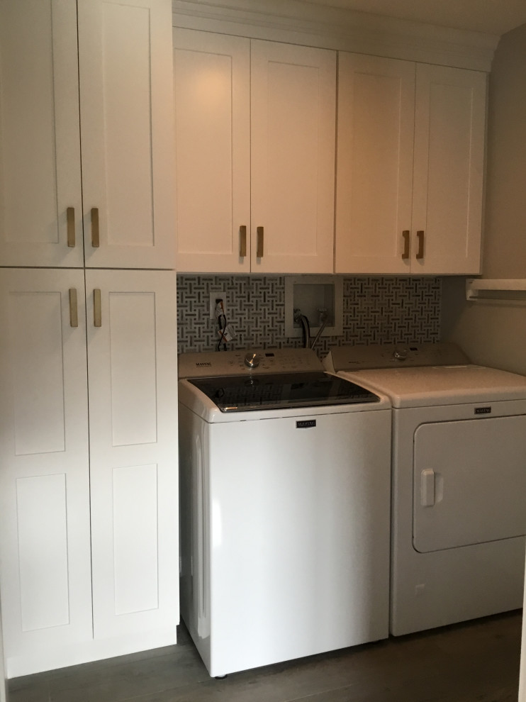 Small modern dedicated laundry room in New York with shaker cabinets, white cabinets, grey splashback, ceramic splashback, grey walls, ceramic floors, a side-by-side washer and dryer and grey floor.