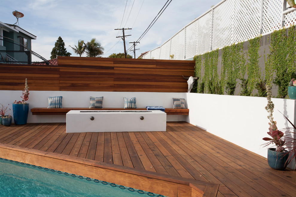 Mid-sized midcentury backyard deck in Los Angeles with a fire feature and no cover.