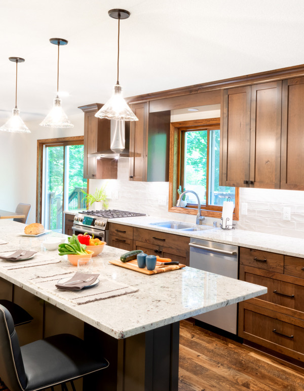 Bild på ett mellanstort vintage vit vitt kök, med en dubbel diskho, skåp i shakerstil, skåp i mellenmörkt trä, granitbänkskiva, vitt stänkskydd, stänkskydd i keramik, rostfria vitvaror, vinylgolv och en köksö