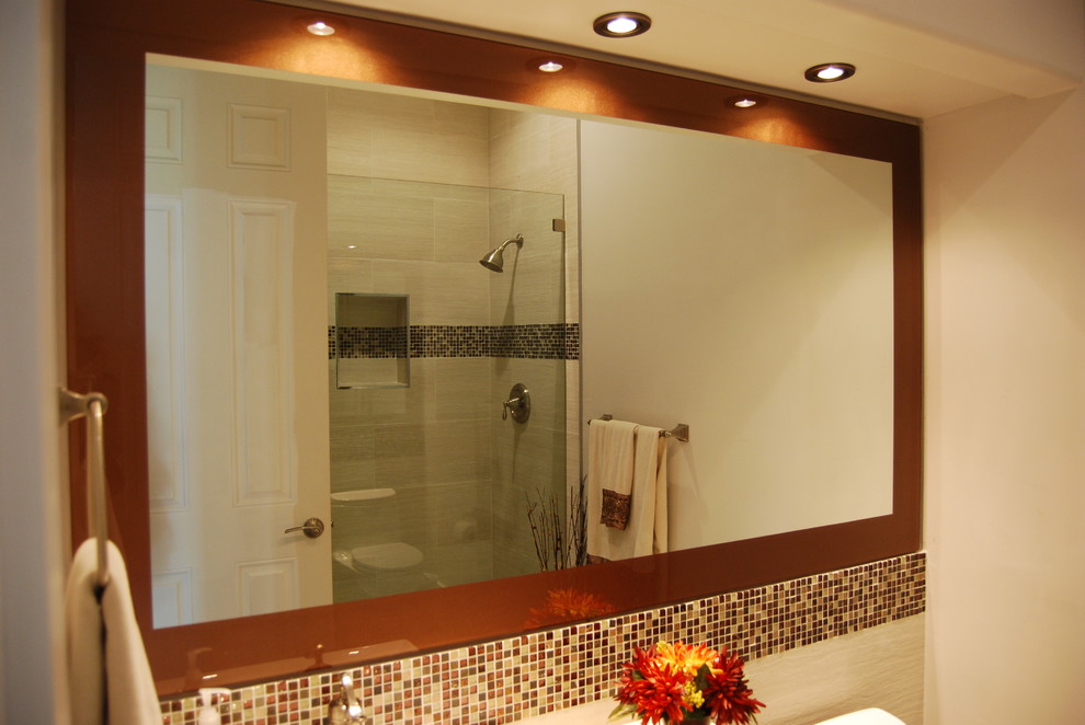 This is an example of a mid-sized contemporary 3/4 bathroom in Miami with an alcove shower, beige tile, brown tile, multi-coloured tile, glass sheet wall, beige walls and a hinged shower door.