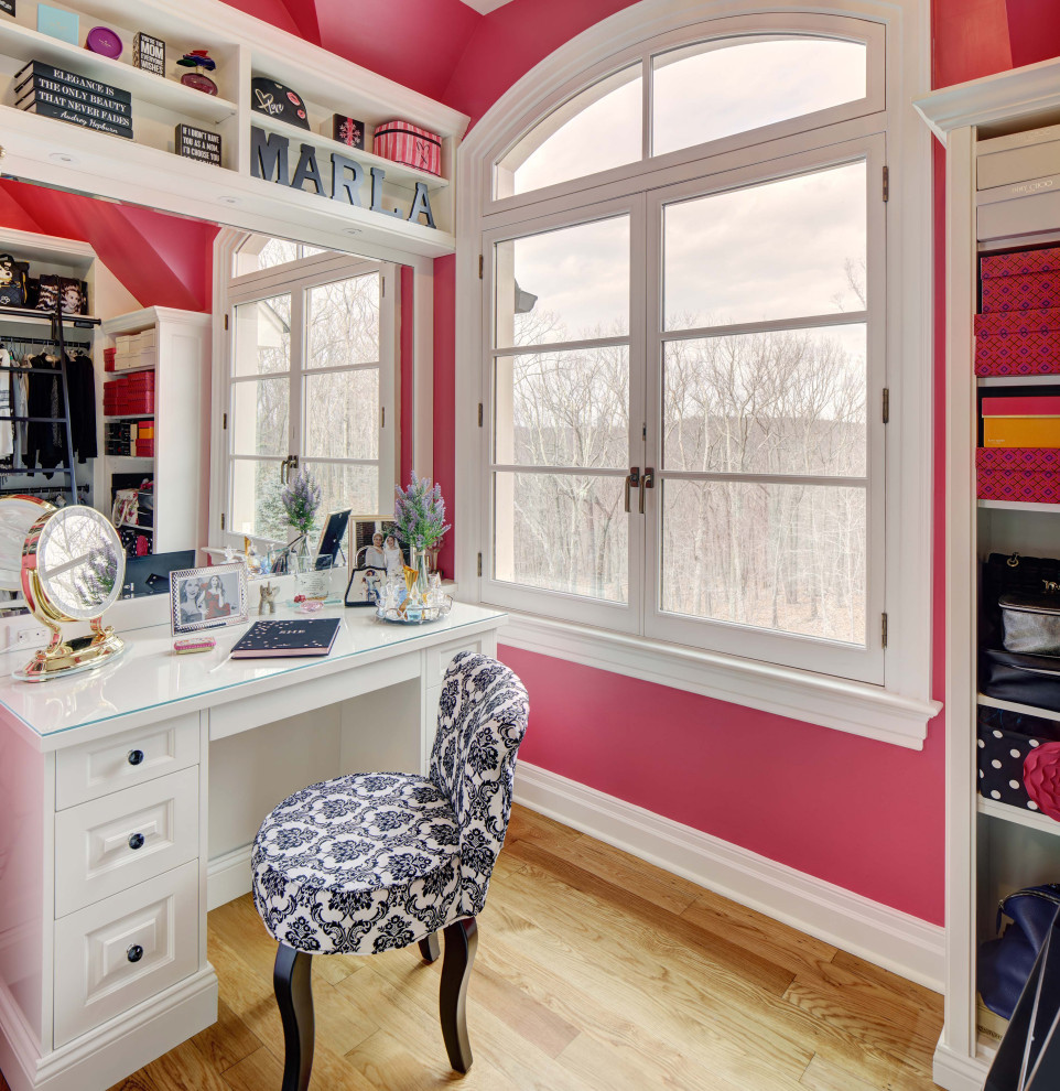 This is an example of a mid-sized eclectic women's storage and wardrobe in New York with shaker cabinets, white cabinets and medium hardwood floors.