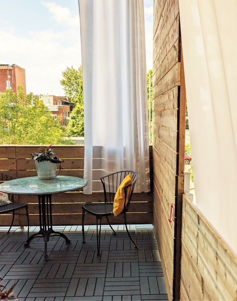 Immagine di un privacy sul balcone minimal di medie dimensioni con un tetto a sbalzo e parapetto in legno