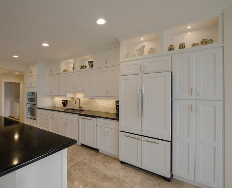 Inspiration for a kitchen remodel in Miami with an undermount sink, shaker cabinets, white cabinets, quartz countertops, beige backsplash, stone tile backsplash and paneled appliances