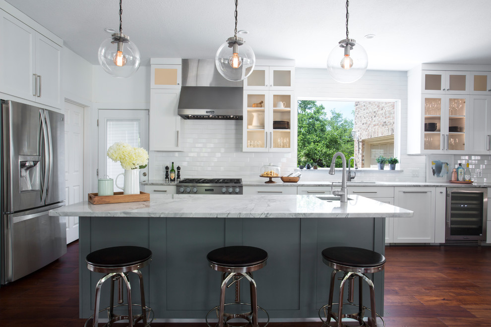 Inspiration for a transitional l-shaped dark wood floor and brown floor kitchen remodel in Austin with an undermount sink, shaker cabinets, gray cabinets, white backsplash, subway tile backsplash, stainless steel appliances, an island and gray countertops