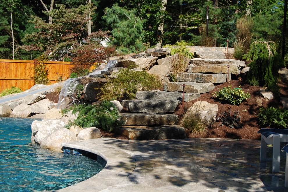 Example of a mid-sized mountain style backyard stone and kidney-shaped natural water slide design in Boston