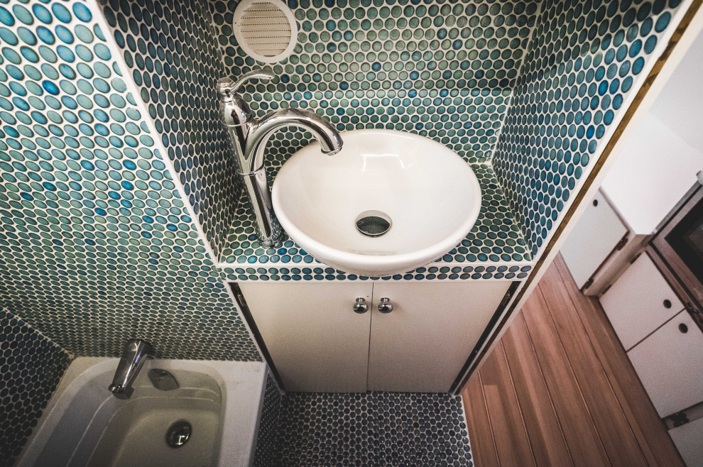 На фото: маленькая главная ванная комната со стиральной машиной в современном стиле с плоскими фасадами, белыми фасадами, накладной ванной, душем над ванной, унитазом-моноблоком, синей плиткой, керамической плиткой, синими стенами, полом из керамической плитки, настольной раковиной, столешницей из плитки, бирюзовым полом, шторкой для ванной, бирюзовой столешницей, тумбой под одну раковину, встроенной тумбой и панелями на стенах для на участке и в саду с