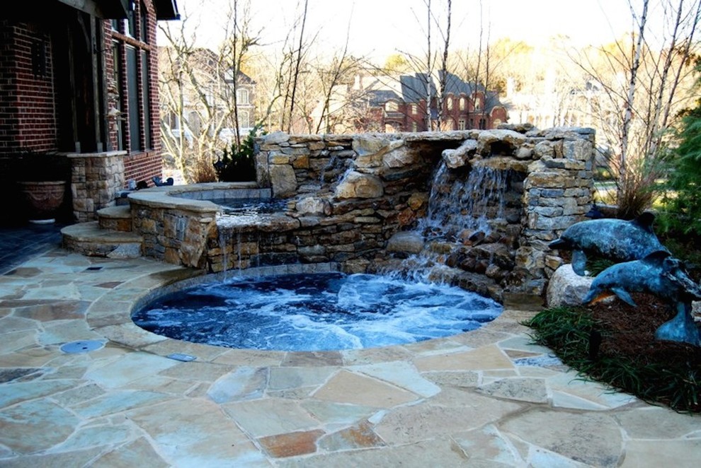 Mid-sized transitional backyard stamped concrete and round hot tub photo in Nashville