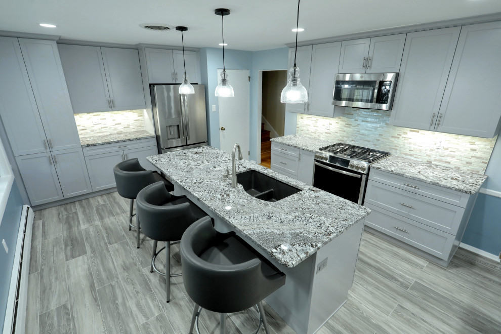 Inspiration for a mid-sized transitional laminate floor and gray floor kitchen remodel with shaker cabinets, granite countertops, multicolored backsplash, mosaic tile backsplash, stainless steel appliances, an island and multicolored countertops