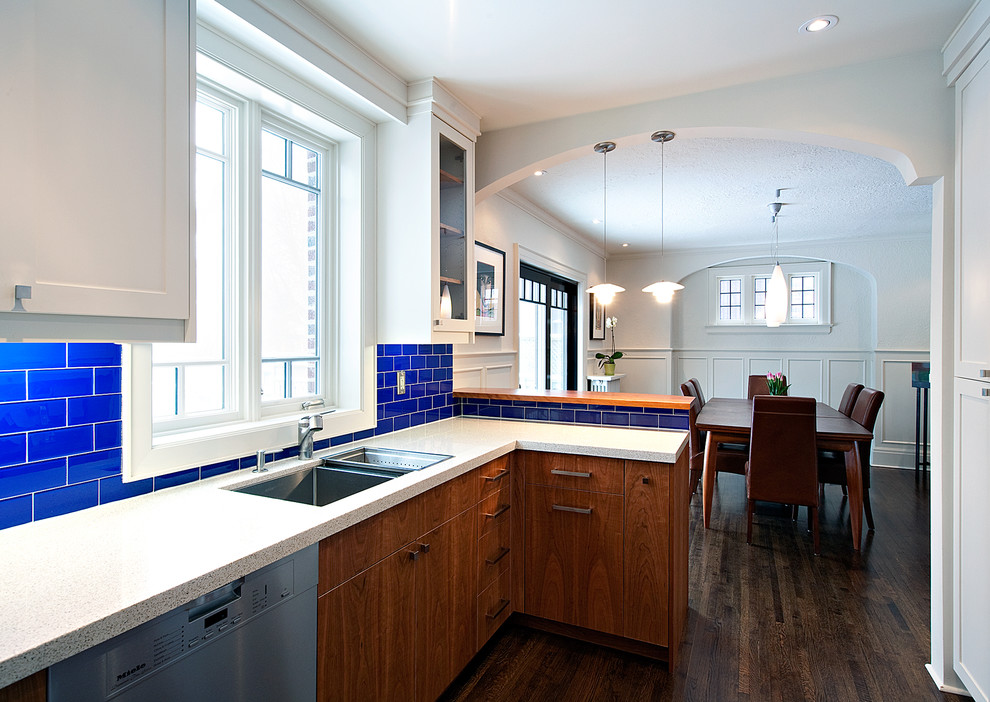 Photo of a contemporary kitchen in Toronto with a double-bowl sink, flat-panel cabinets and dark wood cabinets.