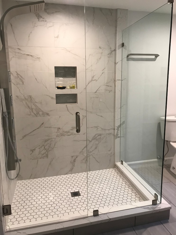 Design ideas for a mid-sized traditional master bathroom in Boston with a corner shower, a two-piece toilet, gray tile, metal tile, grey walls, porcelain floors, grey floor and a hinged shower door.