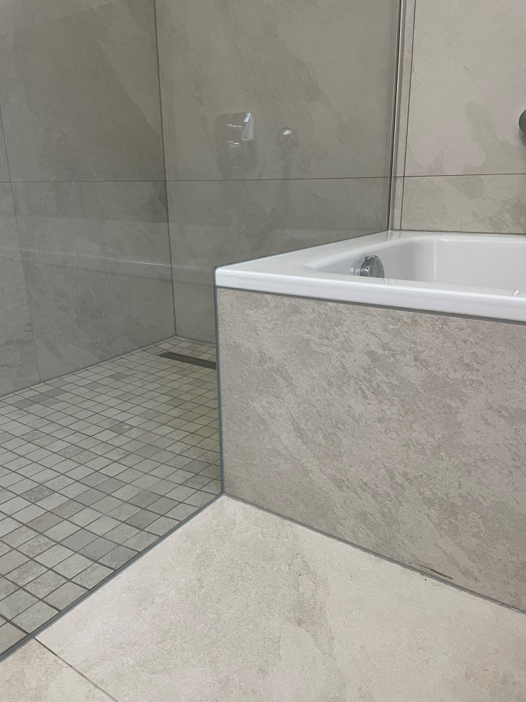 Fliesenlose Dusche En Suite With Unterbauwanne, Duschnische, Wandtoilette, grauen Fliesen, Porzellanfliesen, weißer Wandfarbe, Mosaik-Bodenfliesen, grauem Boden, Falttür-Duschabtrennung, schwebendem Waschtisch and freigelegten Dachbalken