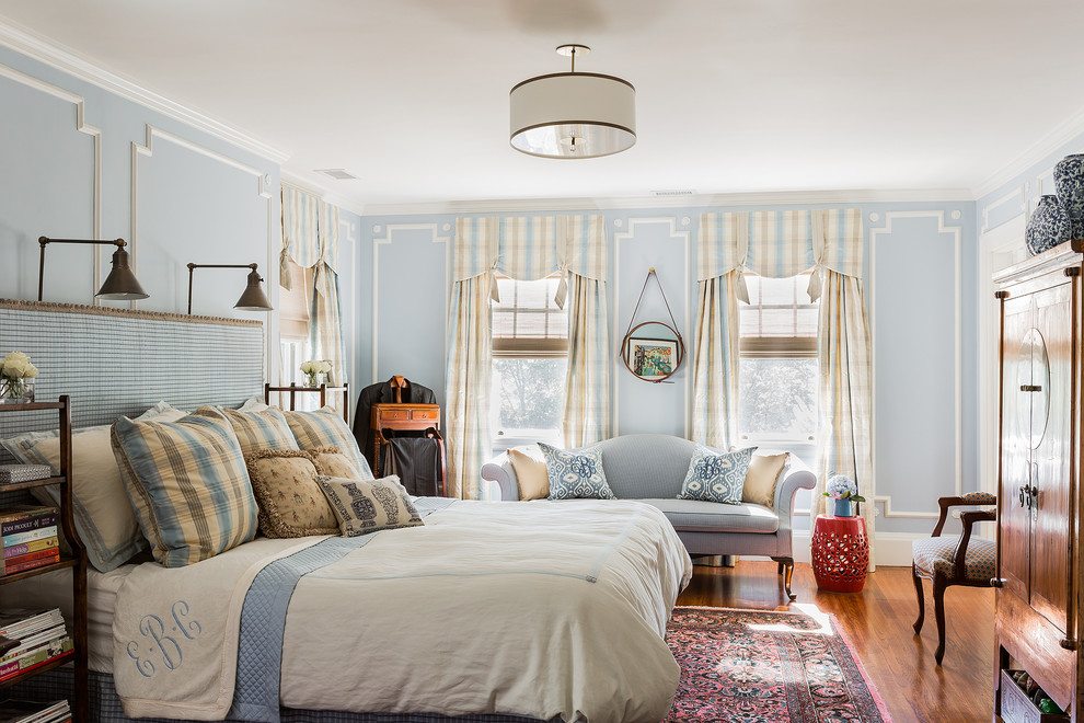 Example of a classic master medium tone wood floor bedroom design in Boston with blue walls