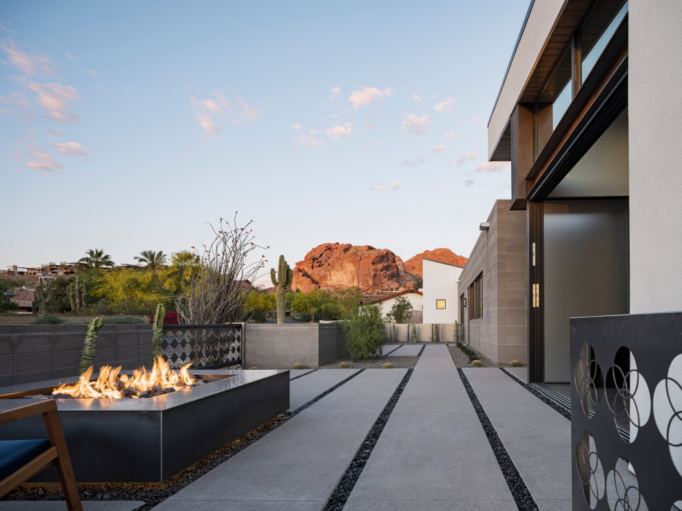 Modern front veranda in Phoenix with a fire feature and concrete paving.