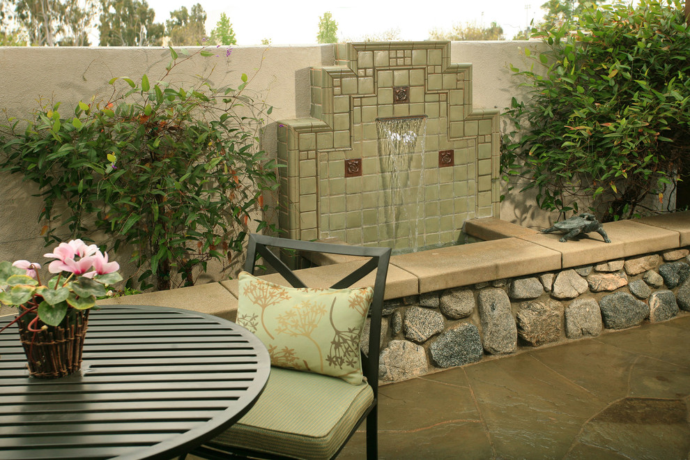 Small asian courtyard patio in Los Angeles with a water feature and natural stone pavers.