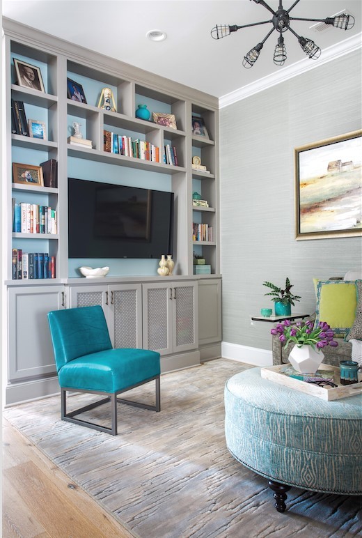 This is an example of a transitional open concept family room in DC Metro with a library, beige walls, light hardwood floors and a built-in media wall.