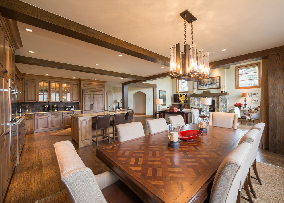 Photo of a large traditional open plan dining in Denver with medium hardwood floors, brown floor, brown walls and exposed beam.