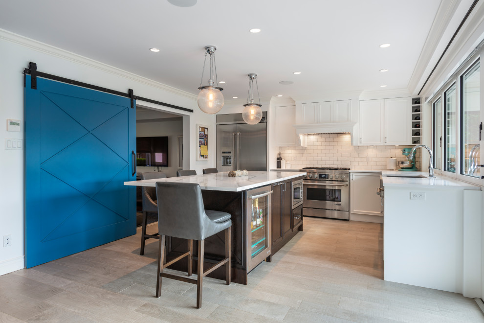 Inspiration for a transitional beige floor kitchen remodel in Vancouver with white backsplash, stainless steel appliances, an island and white countertops