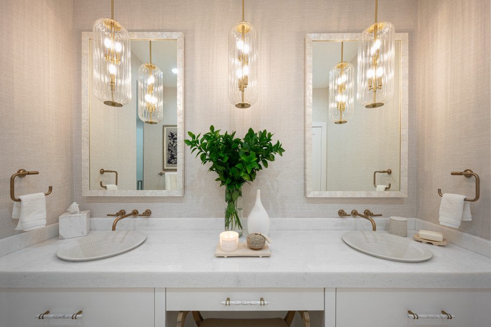 Пример оригинального дизайна: большая главная ванная комната в морском стиле с плоскими фасадами, белыми фасадами, отдельно стоящей ванной, открытым душем, унитазом-моноблоком, белой плиткой, мраморной плиткой, бежевыми стенами, полом из мозаичной плитки, настольной раковиной, мраморной столешницей, белым полом, открытым душем, белой столешницей, нишей, тумбой под две раковины, встроенной тумбой, потолком с обоями и обоями на стенах