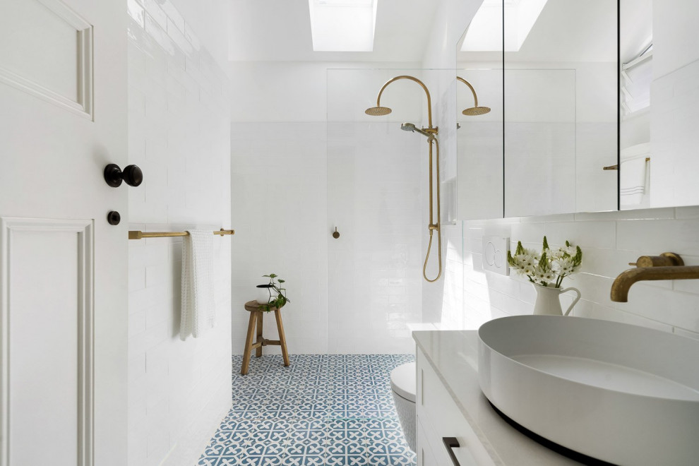 Inspiration for a mid-sized transitional master bathroom in Sydney with shaker cabinets, white cabinets, an alcove shower, a wall-mount toilet, white tile, subway tile, white walls, cement tiles, a vessel sink, engineered quartz benchtops, blue floor, an open shower, grey benchtops, a single vanity, a floating vanity and vaulted.