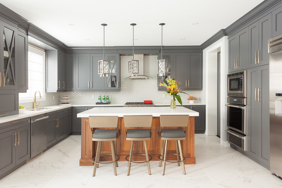 This is an example of a mid-sized transitional u-shaped kitchen in Toronto with a double-bowl sink, shaker cabinets, grey cabinets, quartz benchtops, white splashback, glass tile splashback, stainless steel appliances, porcelain floors and with island.