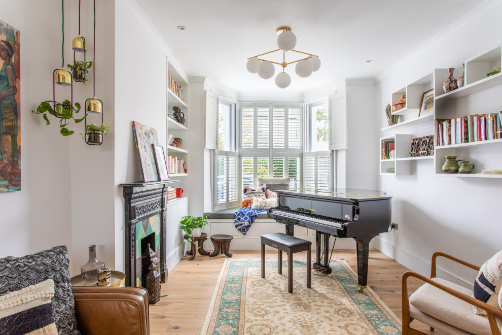 Mid-sized contemporary enclosed living room in London with a music area, grey walls, light hardwood floors, a standard fireplace, no tv and beige floor.