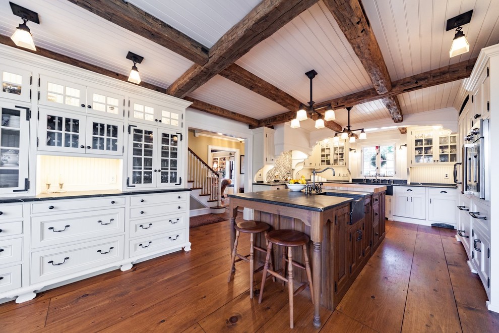 Inspiration for a large transitional u-shaped medium tone wood floor and brown floor eat-in kitchen remodel with a farmhouse sink, recessed-panel cabinets, white cabinets, soapstone countertops, green backsplash, paneled appliances, an island and gray countertops