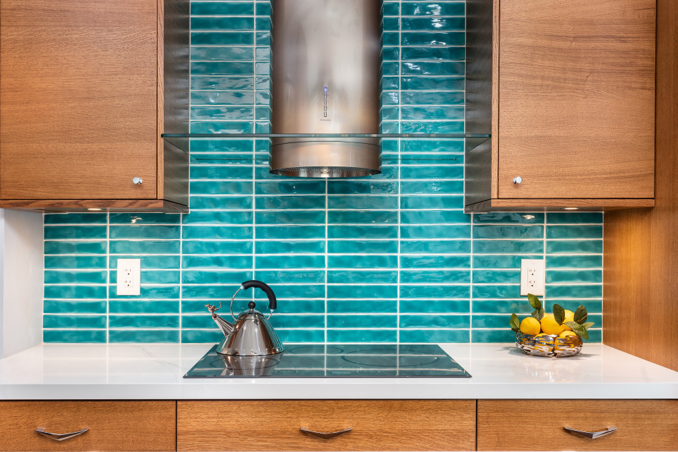 Inspiration for a small retro galley kitchen/diner in Los Angeles with a submerged sink, flat-panel cabinets, medium wood cabinets, engineered stone countertops, blue splashback, stainless steel appliances, laminate floors, an island and white worktops.