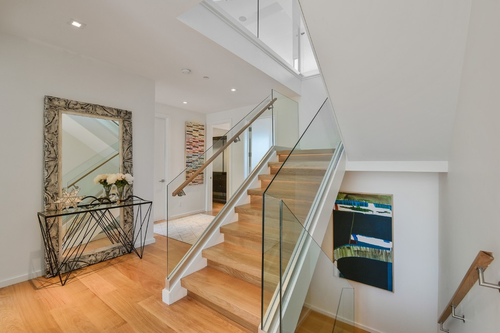 This is an example of a contemporary wood staircase in San Francisco with wood risers and glass railing.