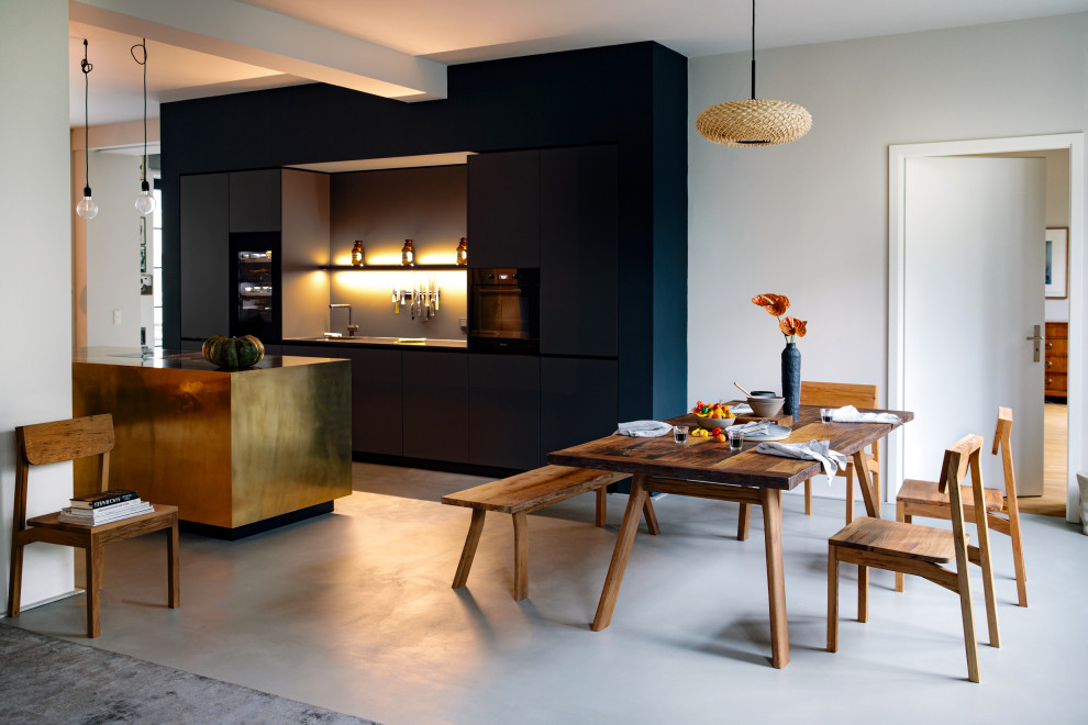 Large contemporary galley eat-in kitchen in Berlin with flat-panel cabinets, black cabinets, with island, grey floor, an undermount sink, grey splashback, black appliances, concrete floors, black benchtop and solid surface benchtops.