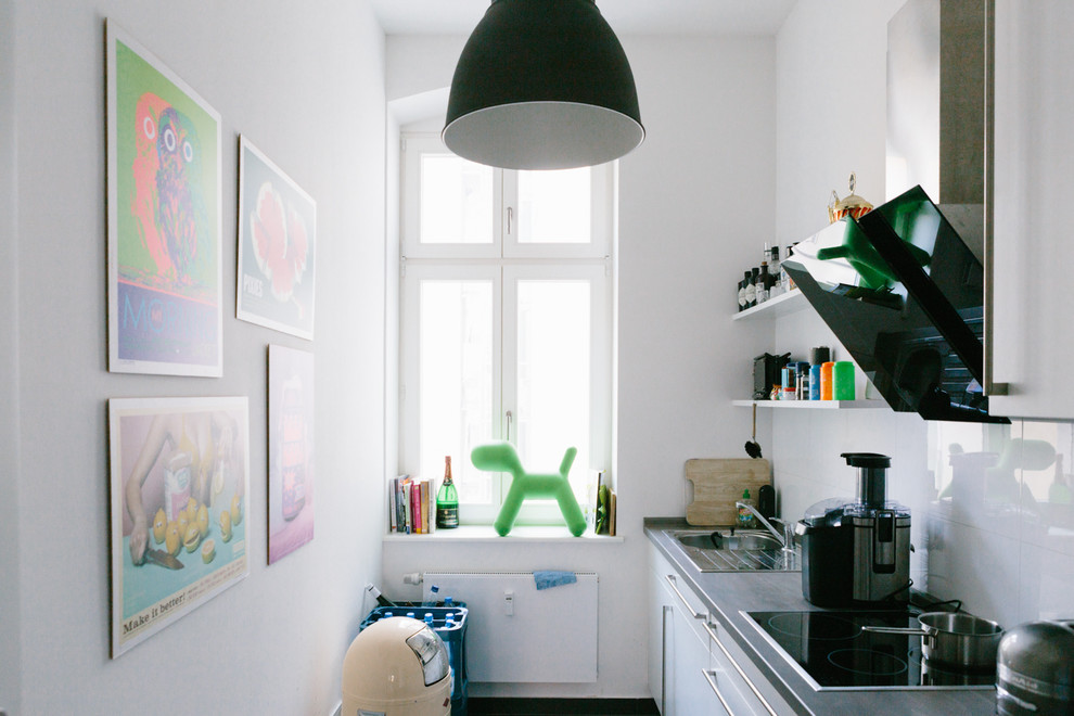 Design ideas for a small eclectic single-wall separate kitchen in Berlin with a drop-in sink, flat-panel cabinets, white cabinets, white splashback, no island and glass tile splashback.