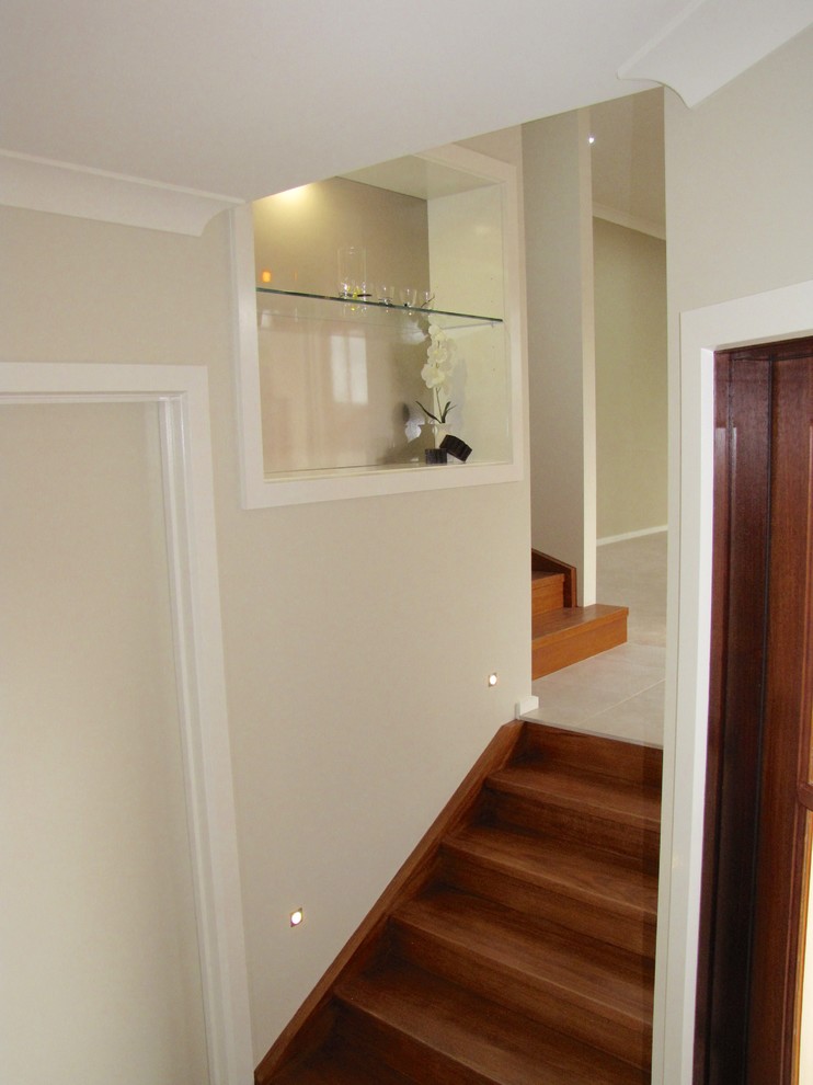 Mid-sized contemporary foyer in Melbourne with beige walls, ceramic floors, a pivot front door and a medium wood front door.