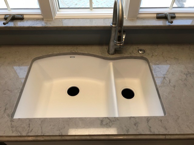 Mid-sized transitional kitchen photo with a double-bowl sink, flat-panel cabinets, white cabinets and an island