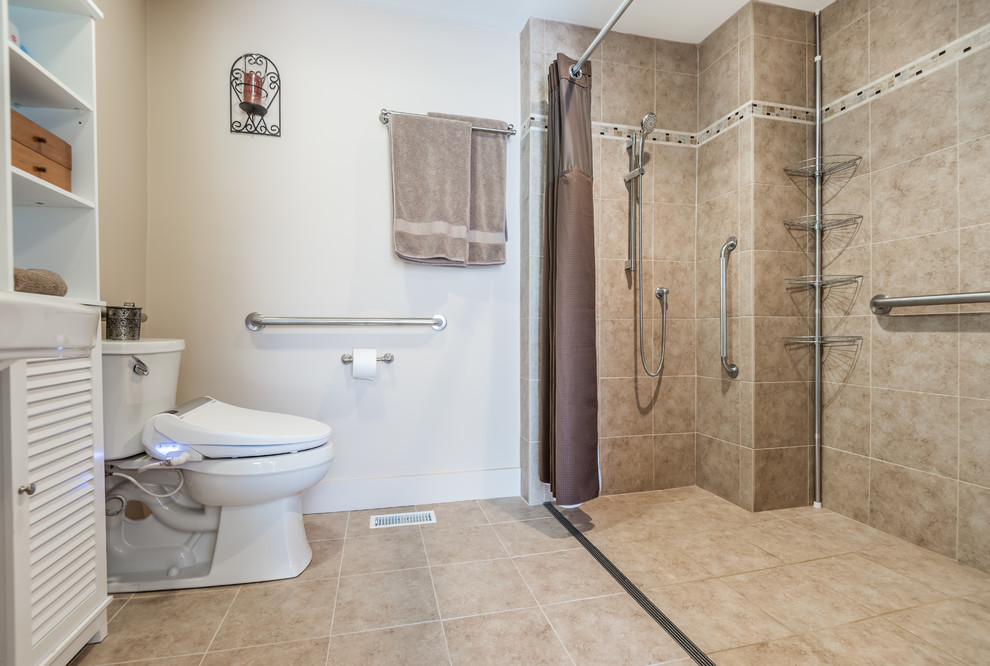 Photo of a mid-sized traditional master bathroom in Boston with a curbless shower, a one-piece toilet, beige tile, white walls, a shower curtain, louvered cabinets, white cabinets, porcelain tile, porcelain floors and an integrated sink.