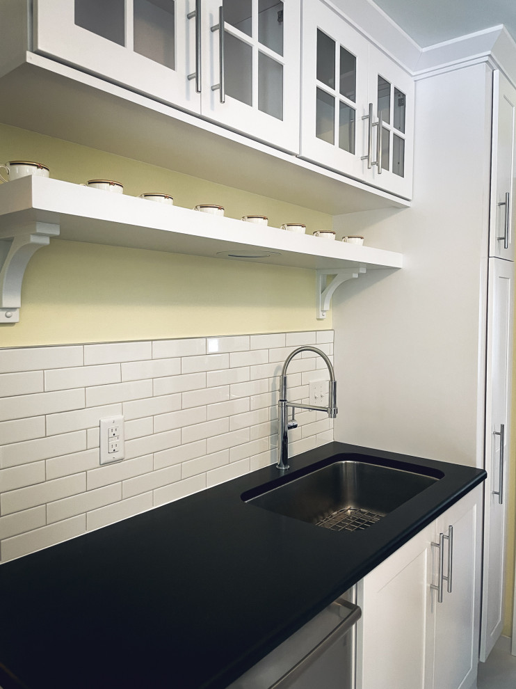 Kitchen - mid-sized ceramic tile and white floor kitchen idea with an undermount sink, white cabinets, quartzite countertops, white backsplash, ceramic backsplash, stainless steel appliances, no island and black countertops