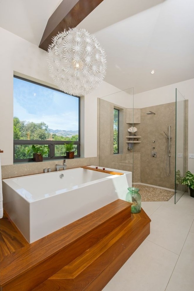 Large tropical master bathroom in Los Angeles with dark wood cabinets, a drop-in tub, a corner shower, black tile, white walls and light hardwood floors.