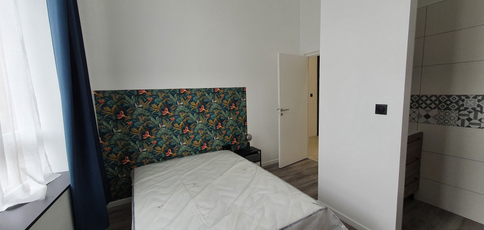 Medium sized classic bedroom in Lille with white walls, grey floors and wallpapered walls.