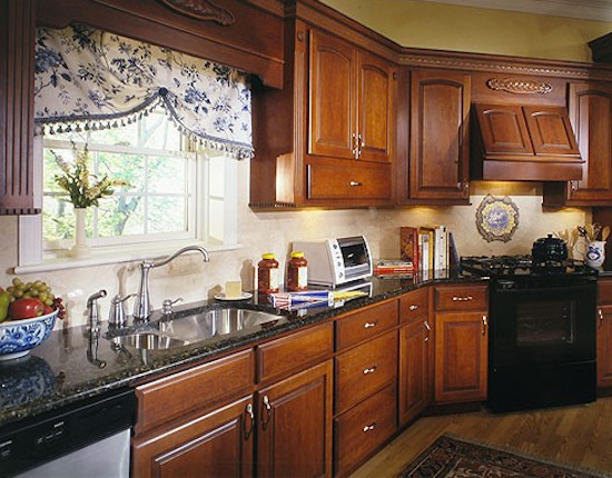 Eat-in kitchen - mid-sized u-shaped medium tone wood floor eat-in kitchen idea with a drop-in sink, dark wood cabinets, granite countertops, beige backsplash and stainless steel appliances