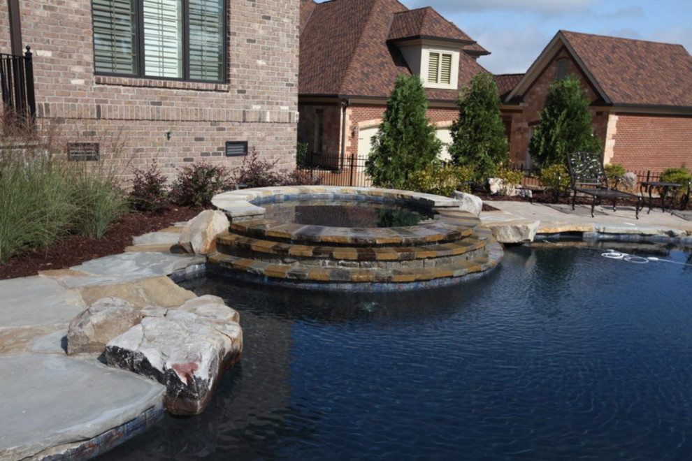 Hot tub - large rustic backyard stone and custom-shaped lap hot tub idea